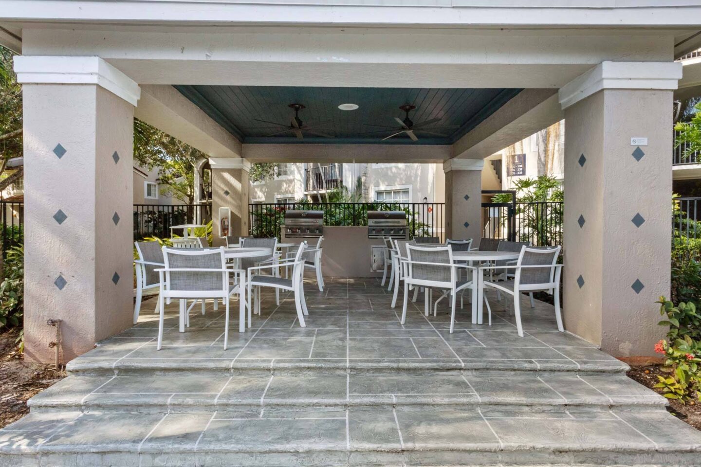 A patio with a table and chairs under a roof.