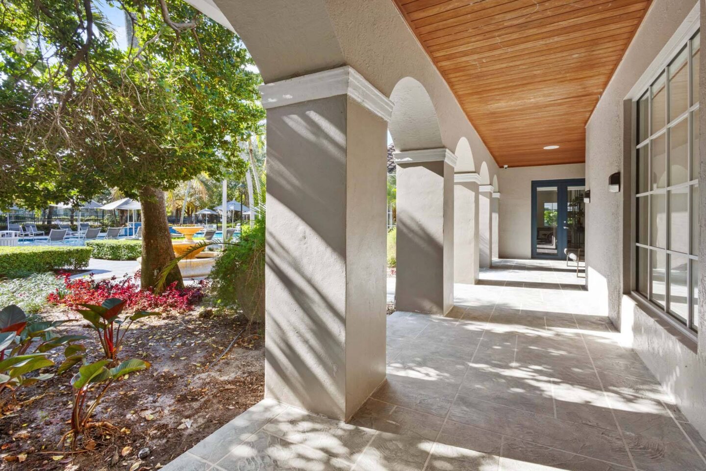 A long hallway with a tree and plants on the side at Windsor Coconut Creek, Coconut Creek, 33073.