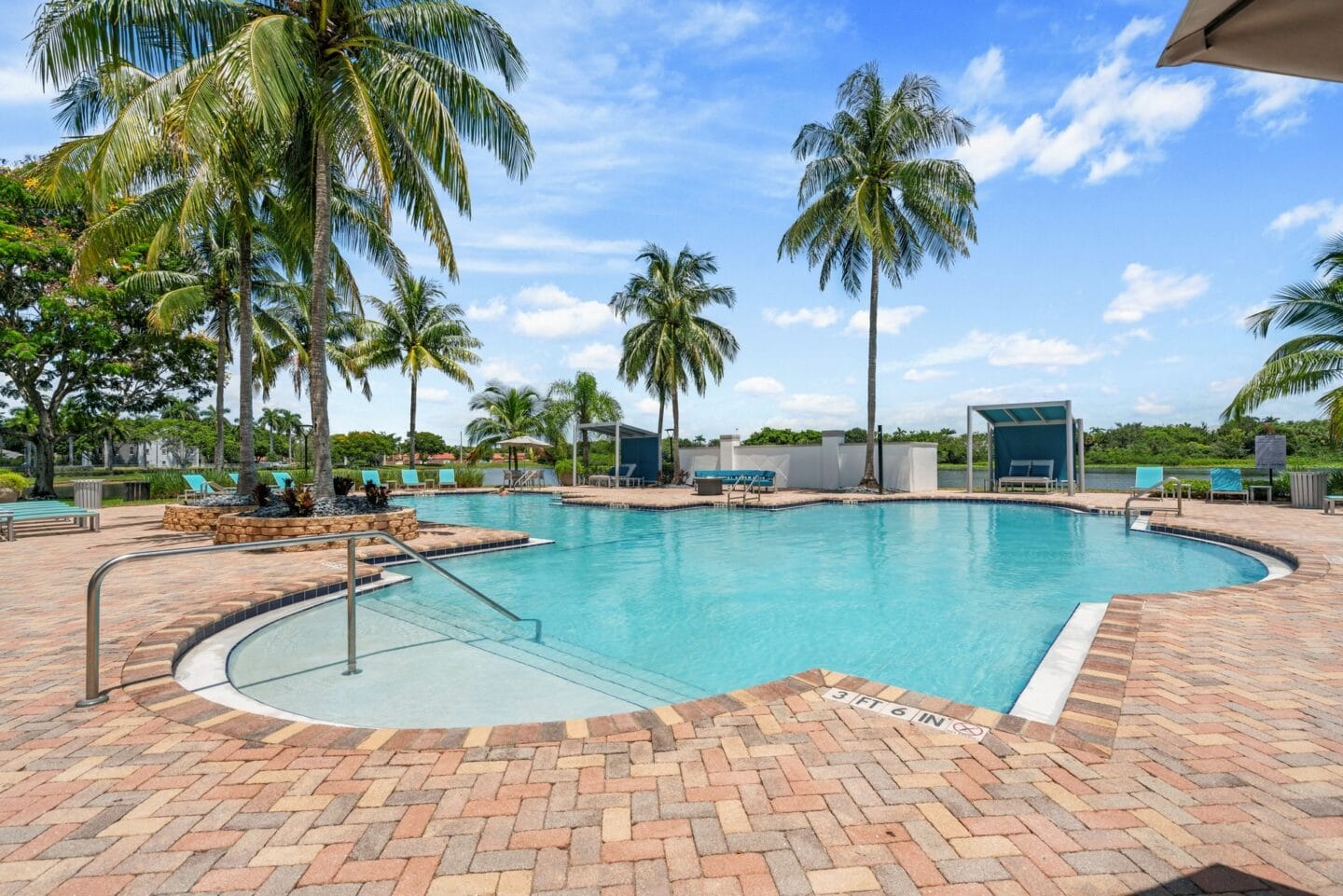 a large swimming pool with palm trees