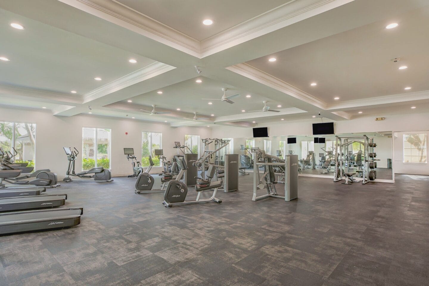 a spacious fitness room with a variety of exercise equipment