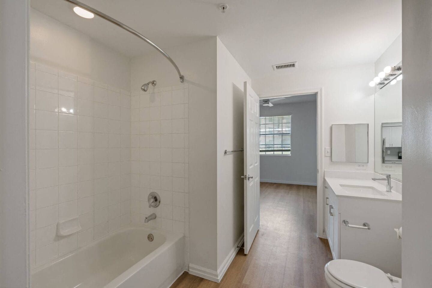 a white bathroom with a tub and a sink