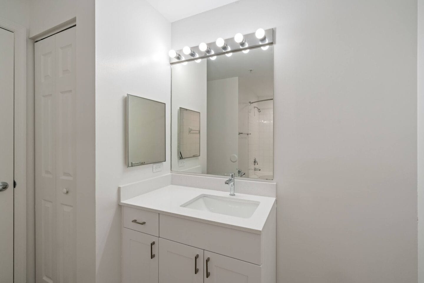 a bathroom with a sink and a mirror and a door