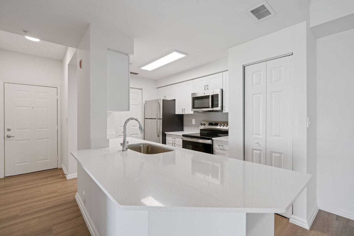 a white kitchen with an island and a sink