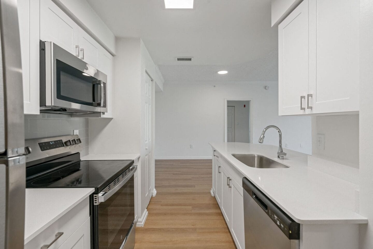 a renovated kitchen with white cabinets and stainless steel appliances