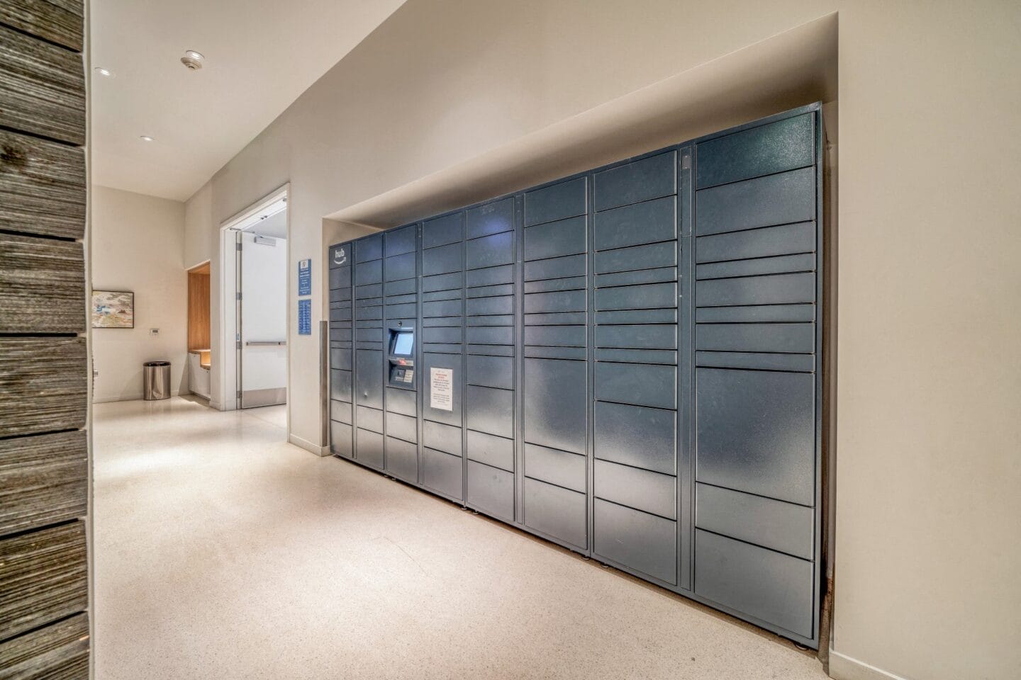 a row of lockers in a hallway with a door open