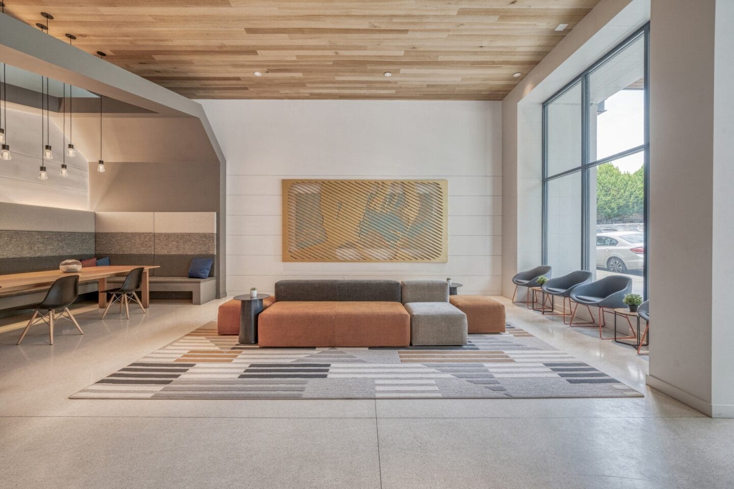 A seating area with a couch and chairs in front of a large window  at Windsor Buckman, Portland, Oregon