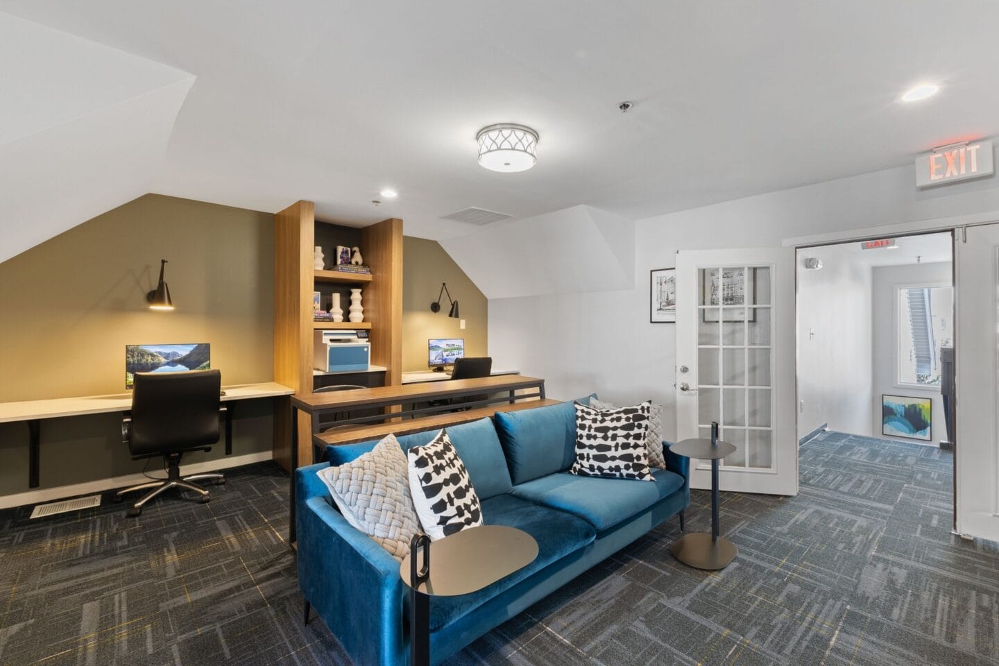 a living room with a blue couch and a desk with a chair