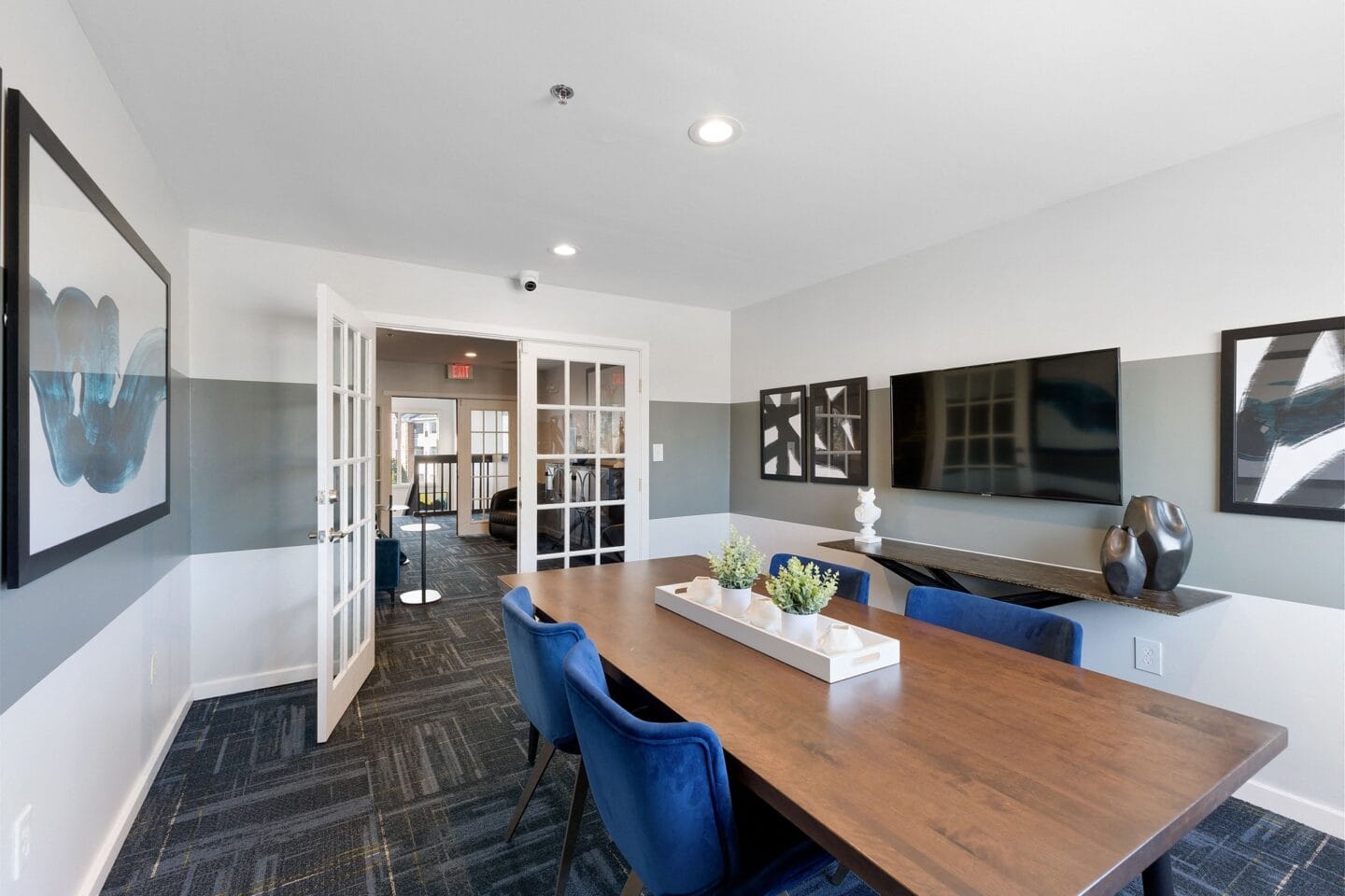 a conference room with a long wooden table and blue chairs