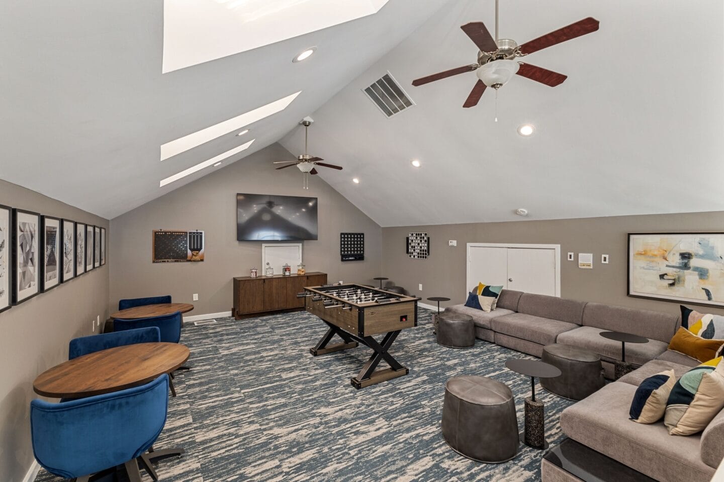 a living room with a pool table and a ceiling fan