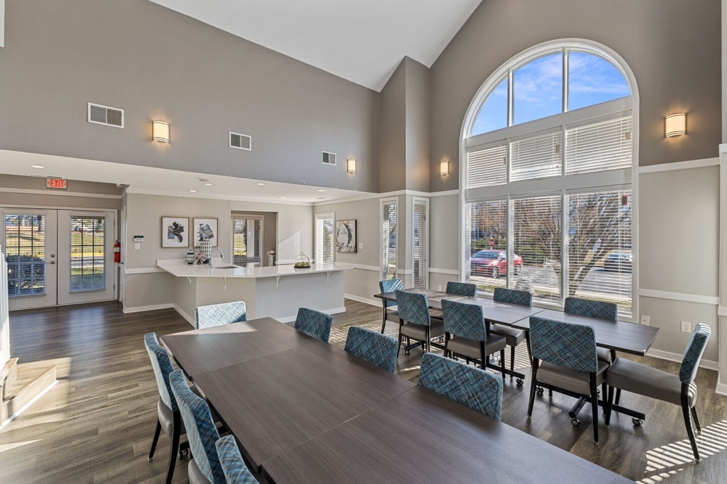 a large dining room with a large window and a table with chairs