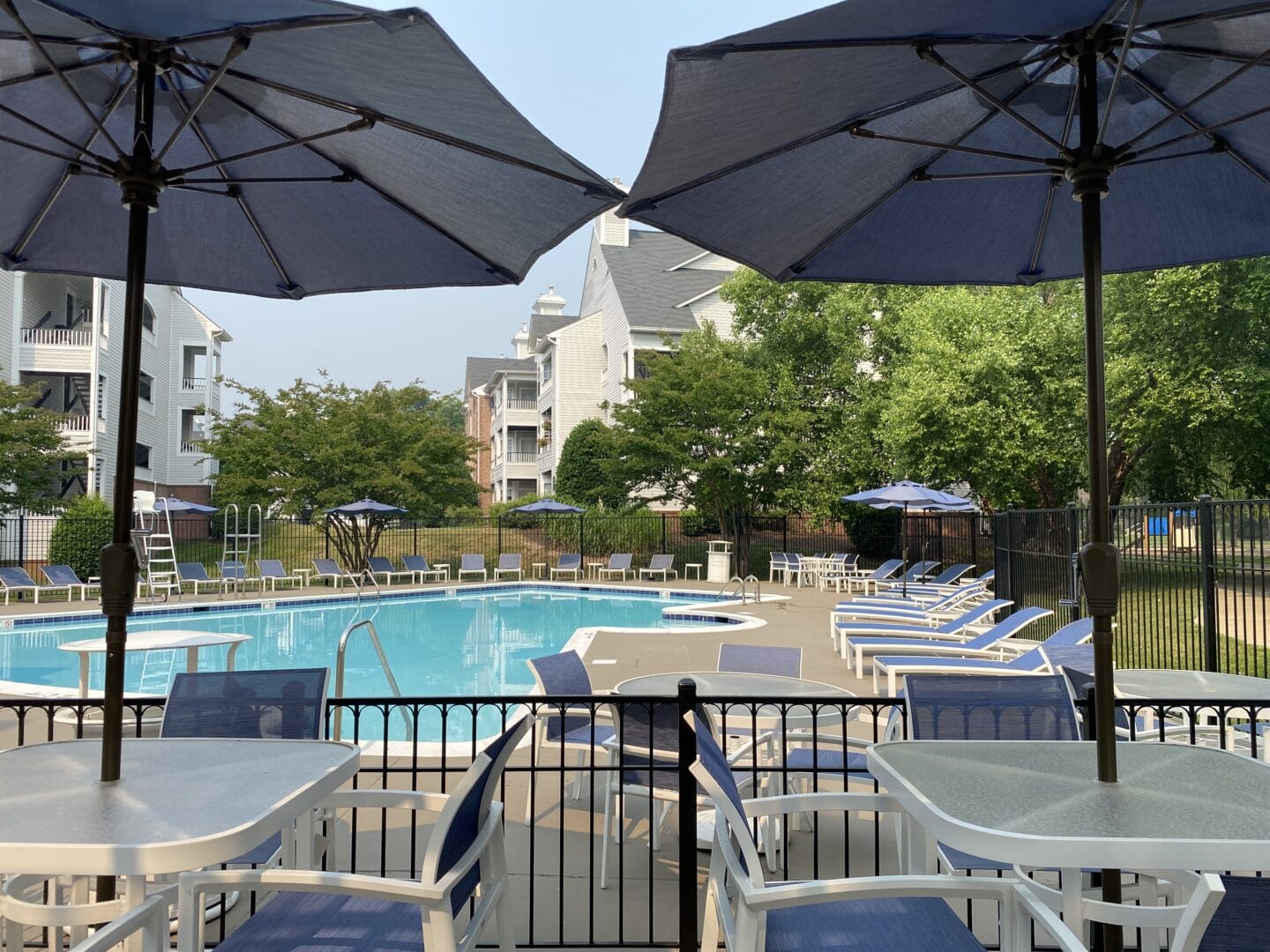 a swimming pool with tables and umbrellas at the resort