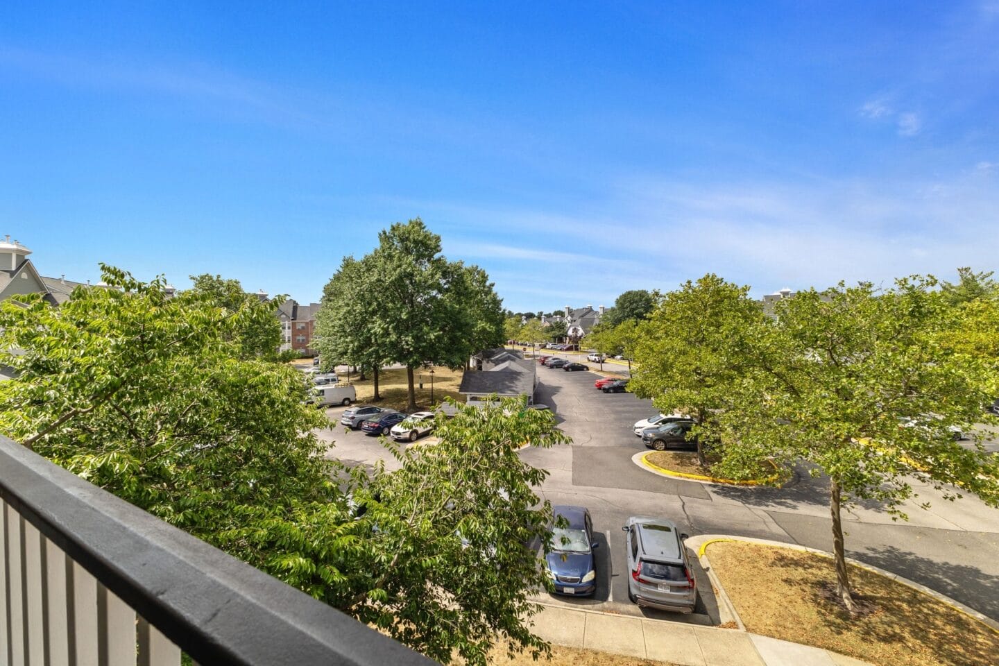 the view of a parking lot from a balcony with cars parked