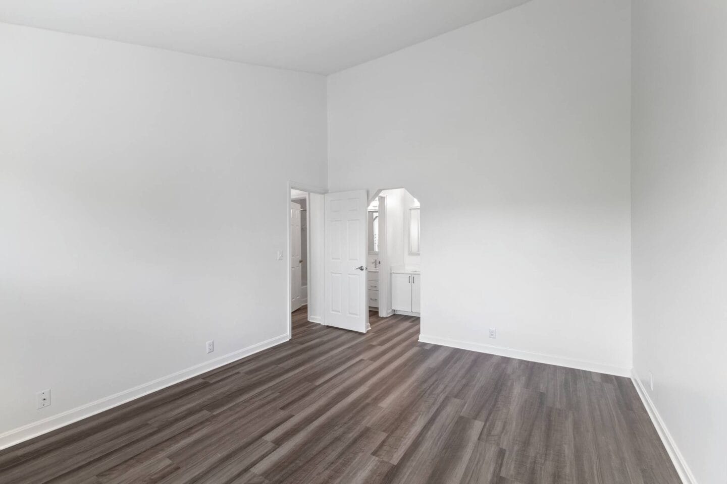 a living room with white walls and wood floors