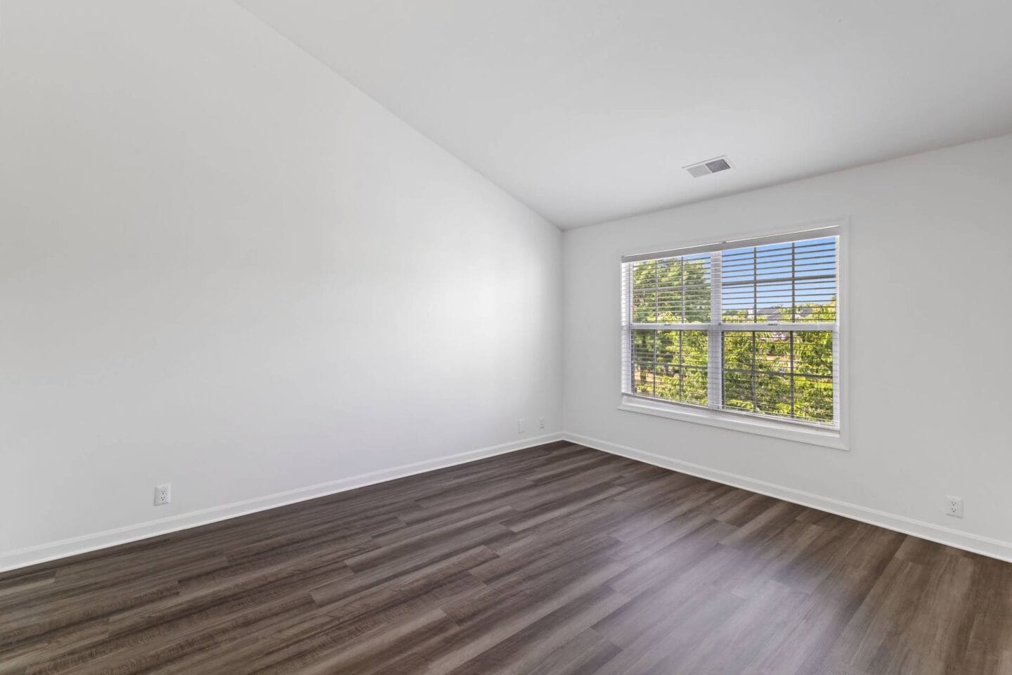 an empty living room with white walls and a window