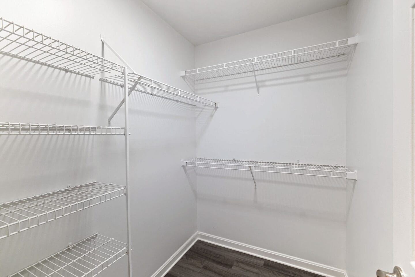 the closet in a bedroom with white walls and a mirrored closet door