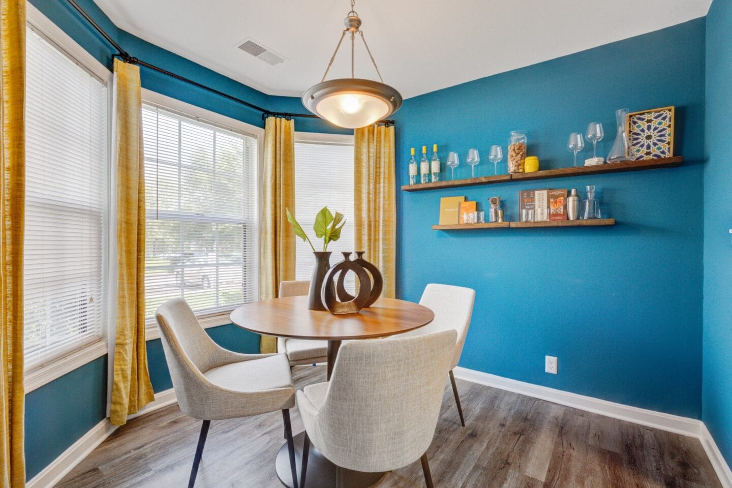 Dining room with blue accent wall and yellow curtains at Windsor Kingstowne, Alexandria, VA 22315