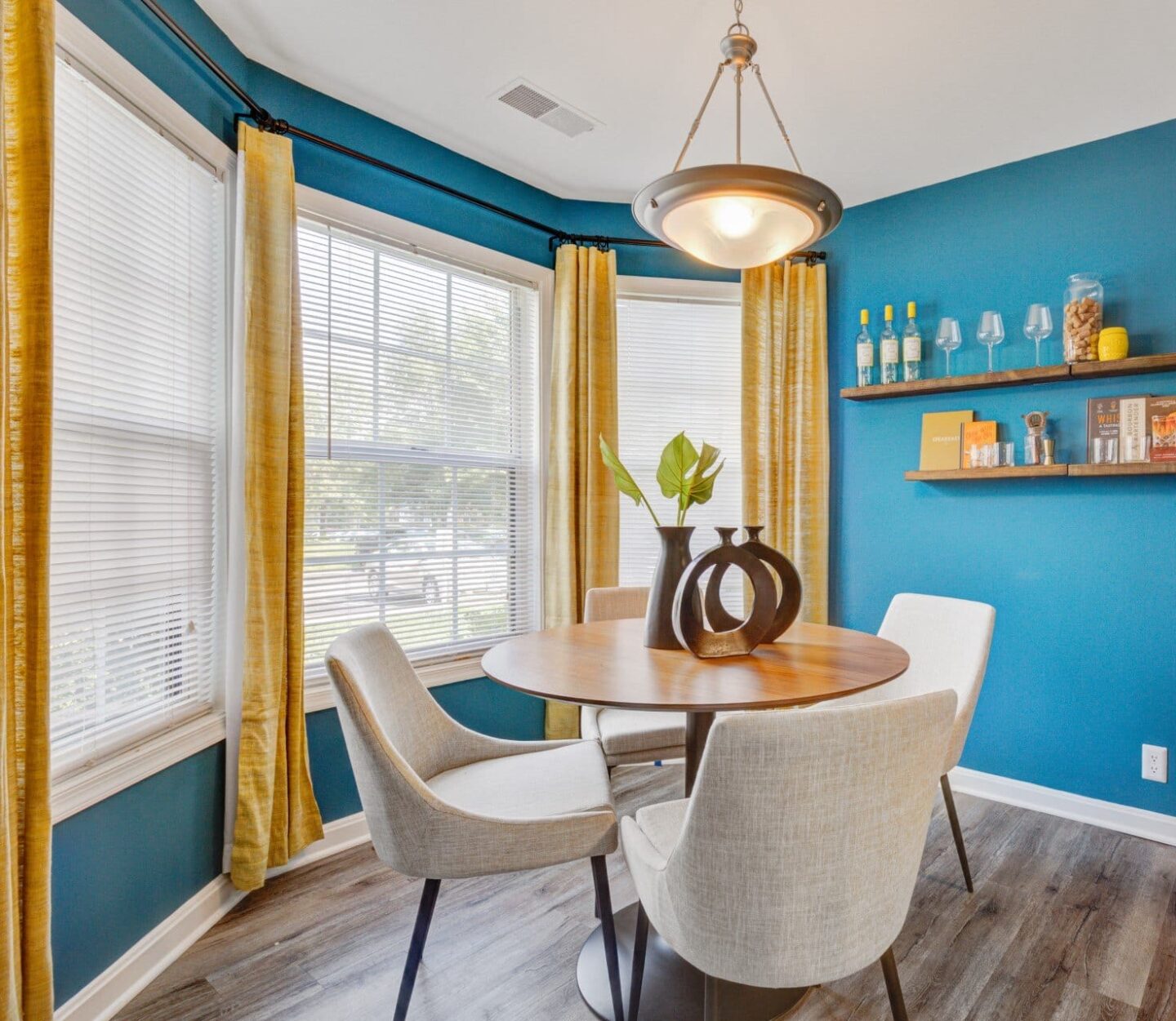 Dining room with blue accent wall and yellow curtains at Windsor Kingstowne, Alexandria, VA 22315