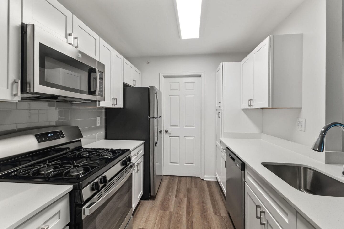 a kitchen with white cabinets and stainless steel appliances