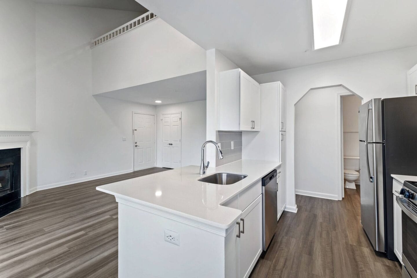 a white kitchen with a sink and a refrigerator