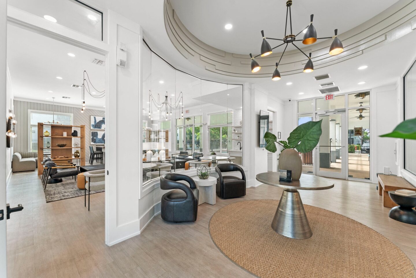 a living room with a round table and chairs and a large mirror