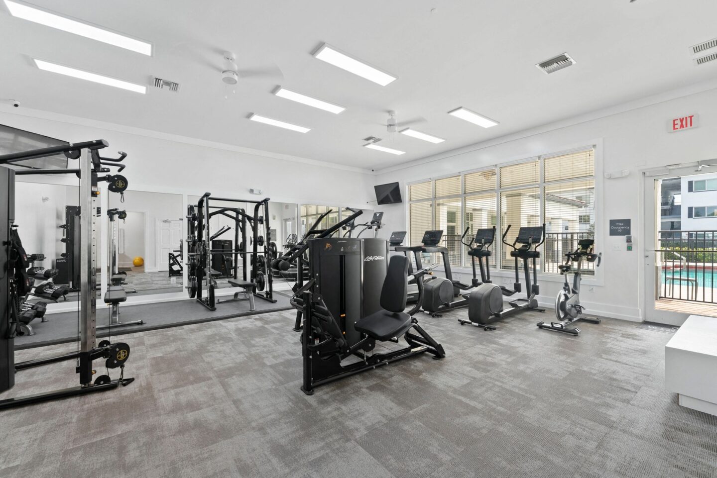 a gym with weights and cardio equipment in a building