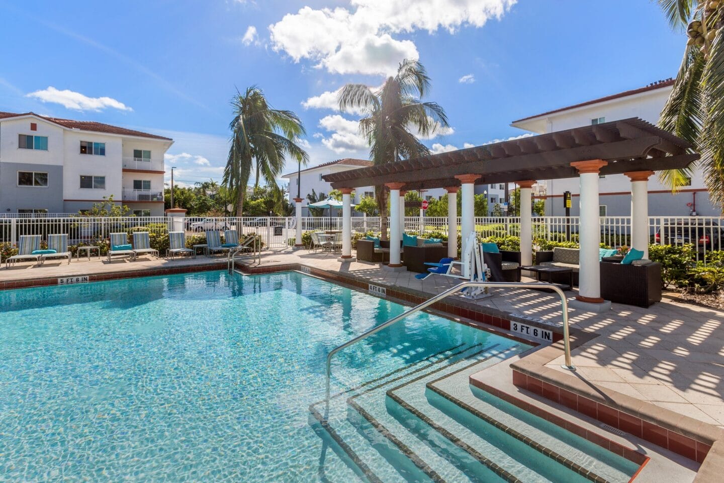 Resort style pool with lounge chairs and a pergola at Windsor Biscayne shores in North Miami