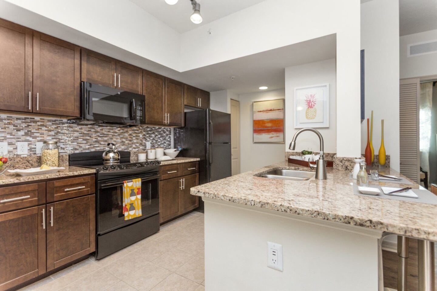 Kitchen with brown cabinets and a granite countertop at Windsor Biscayne Shores  in North Miami