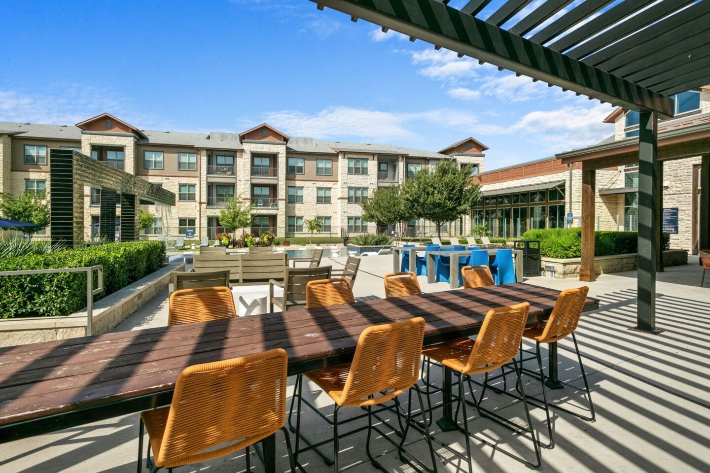 A large patio with tables and chairs and a building in the background at The Lakeyard District