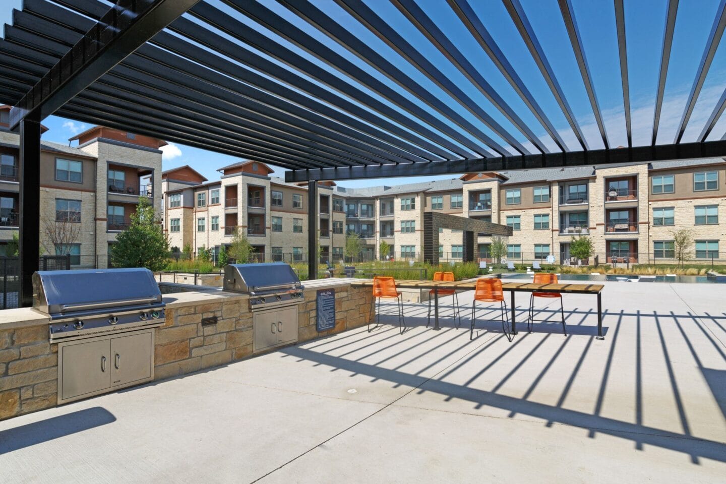 Outdoor patio with barbecue grills at Windsor Lakeyard District, an apartment community in North Dallas