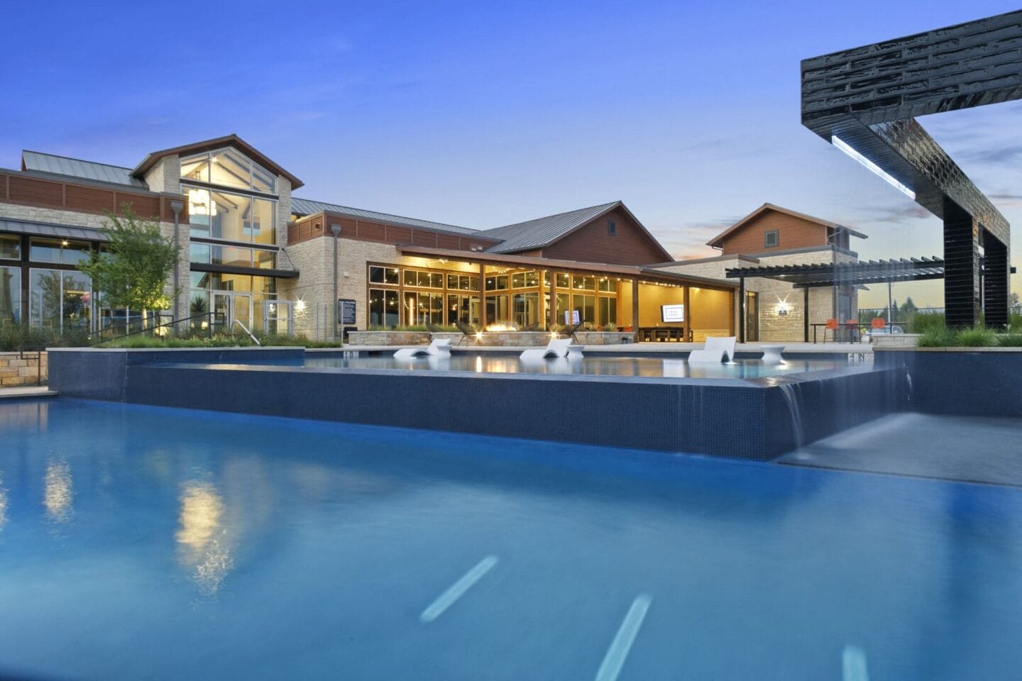 Resort style pool with outdoor seating at Windsor Lakeyard District, an apartment community in North Dallas