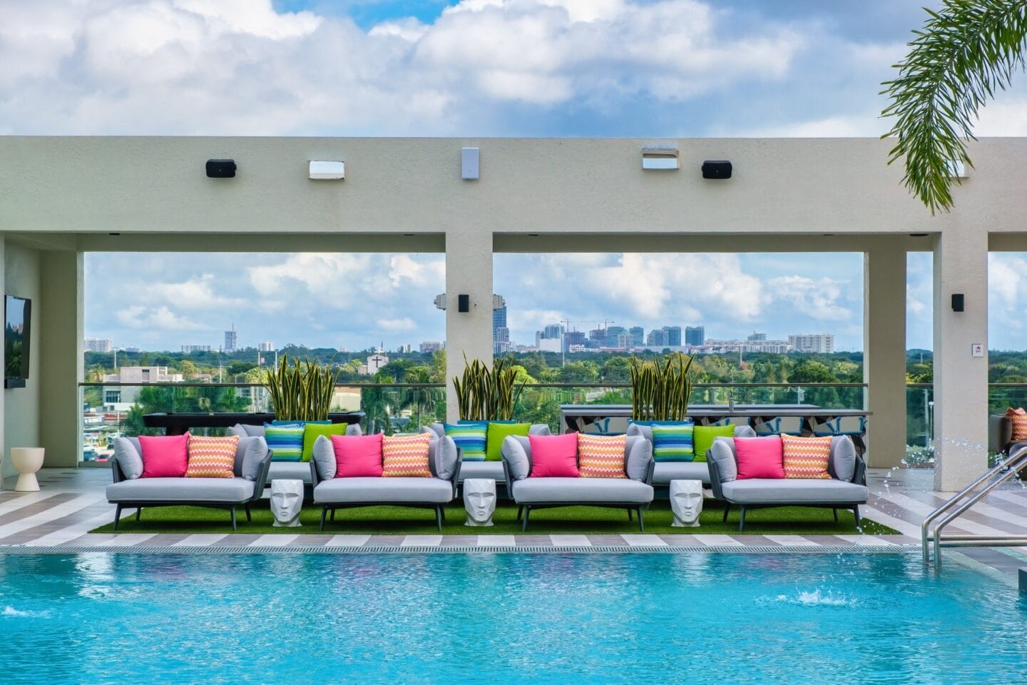 Lounge area next to a pool with a view of the city at Windsor Ludlam Trail in Miami, FL.