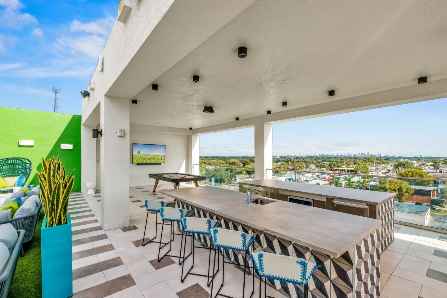 Long wooden table with blue chairs at Windsor Ludlam Trail in Miami, FL.