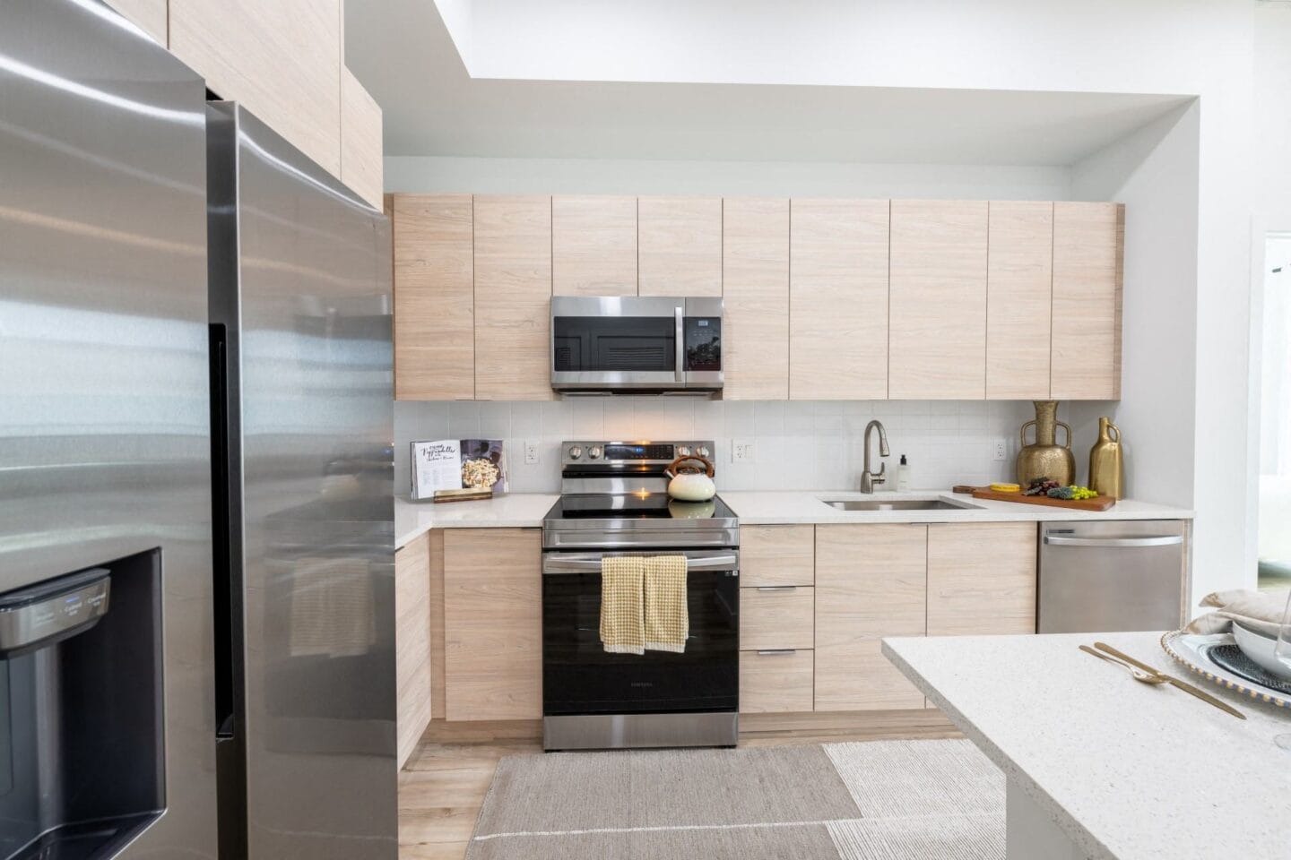 Kitchen with wooden cabinets and stainless steel appliances at Windsor Ludlam Trail in Miami, FL.