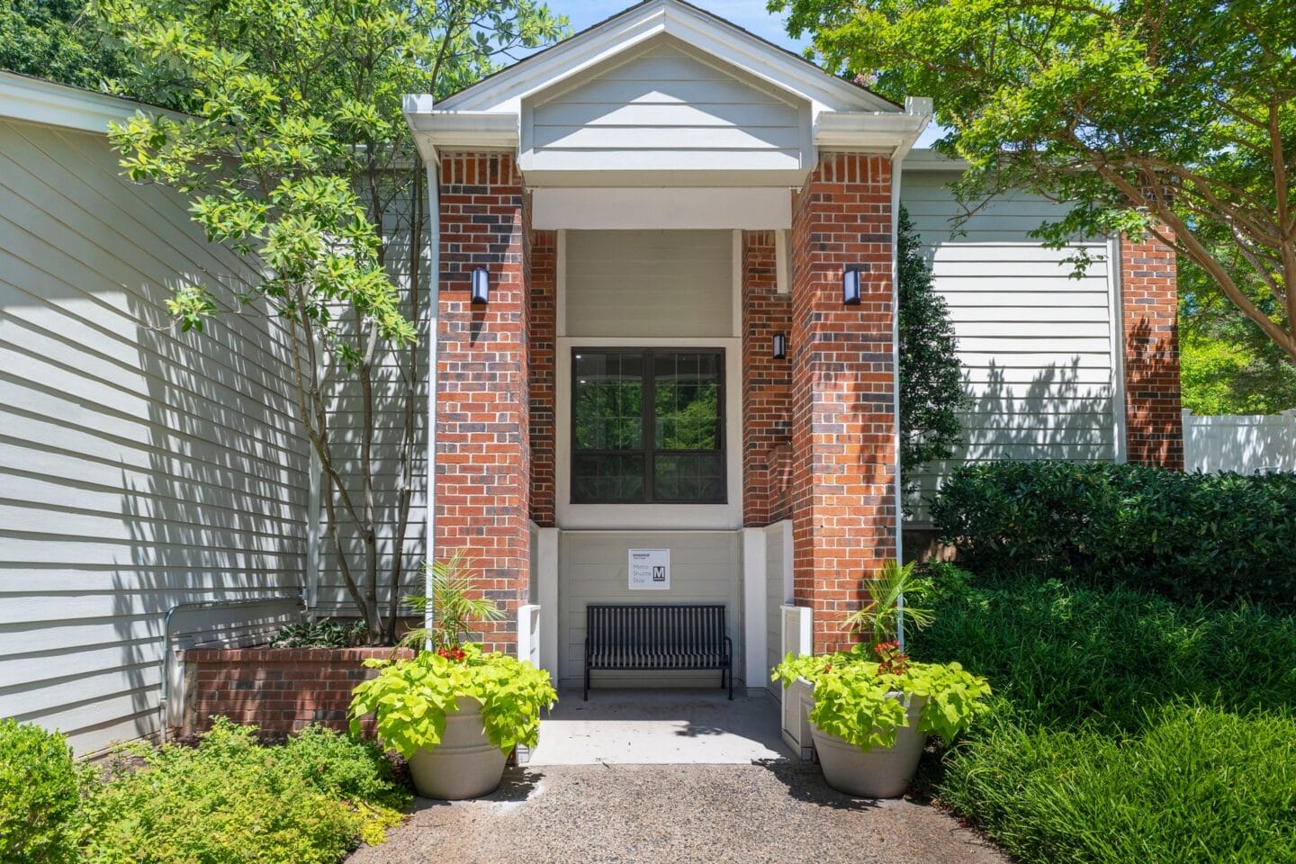 the front of a house with a walkway and two potted plants