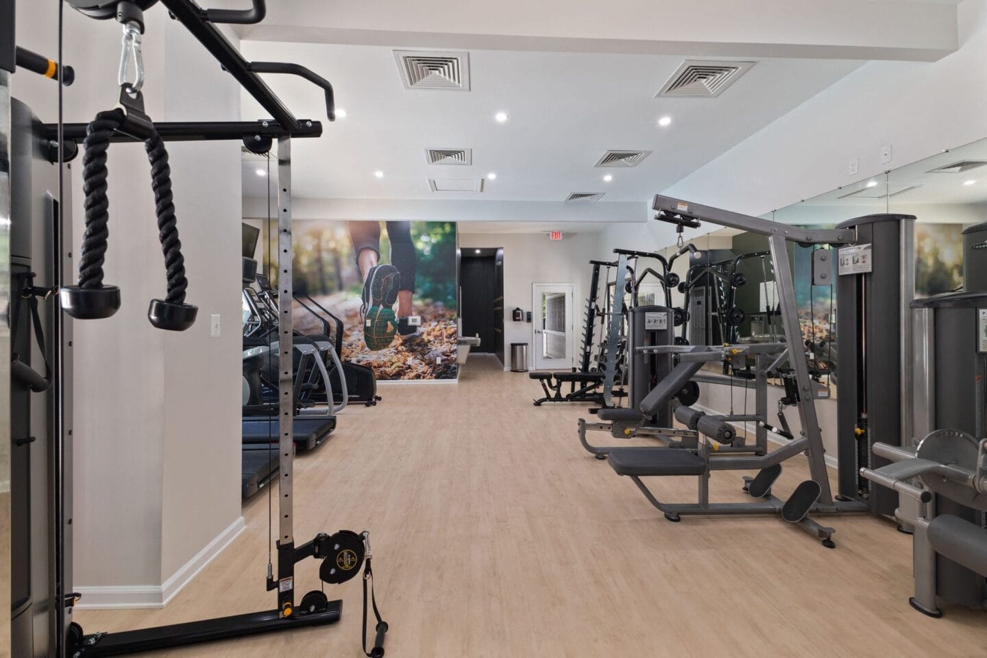 a gym with exercise equipment and a painting on the wall