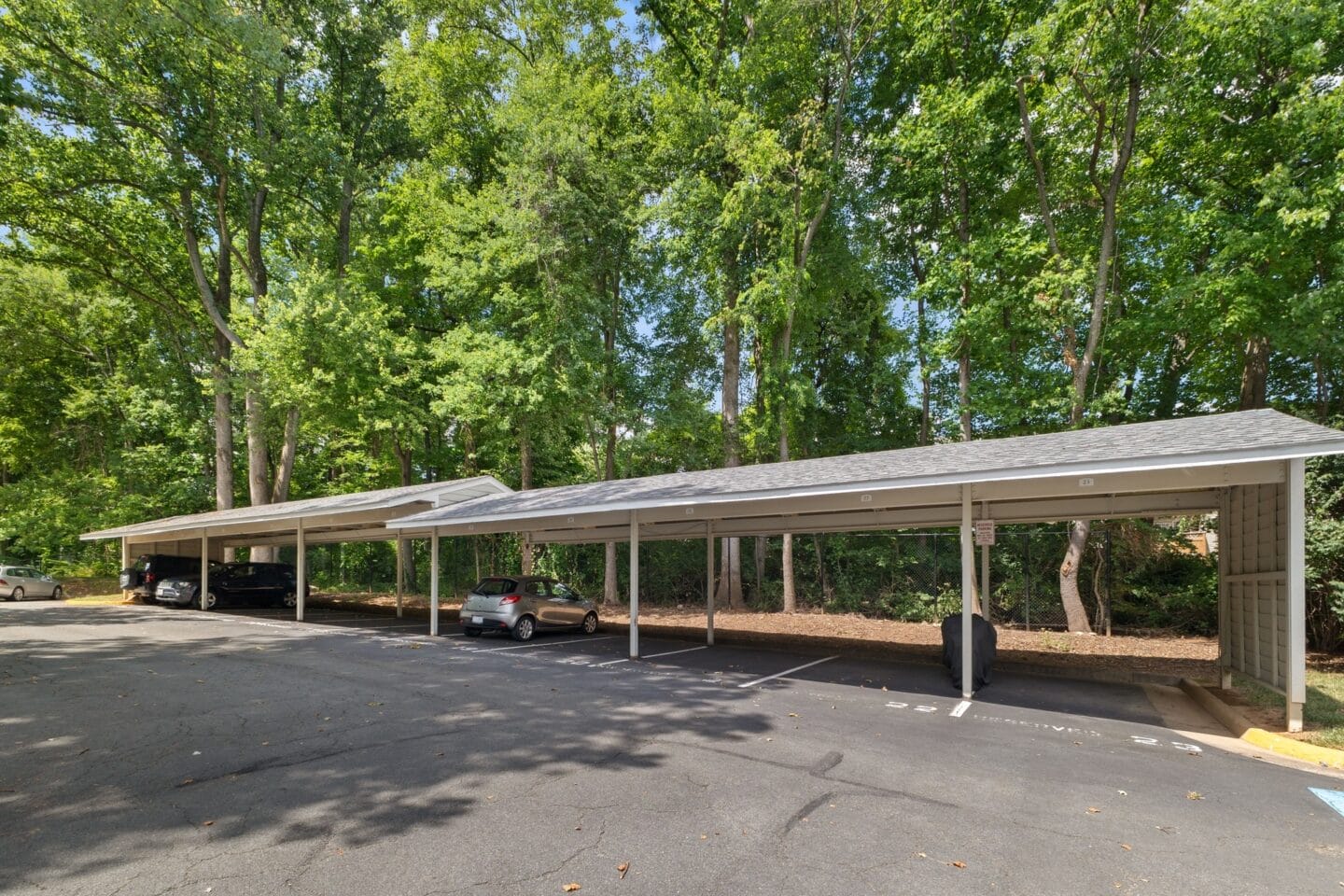 a parking lot with a pavilion with cars under it