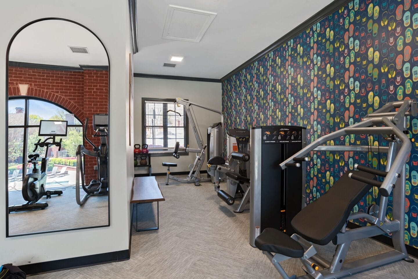 a gym with cardio equipment and a mirror on the wall