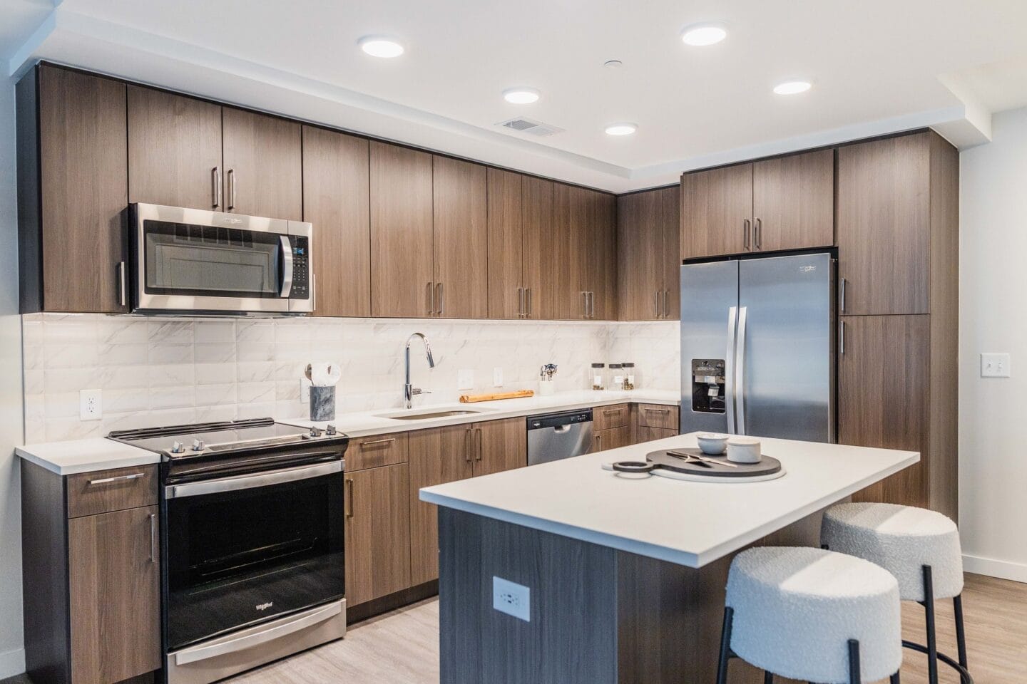 a kitchen with a large island and a stainless steel refrigerator