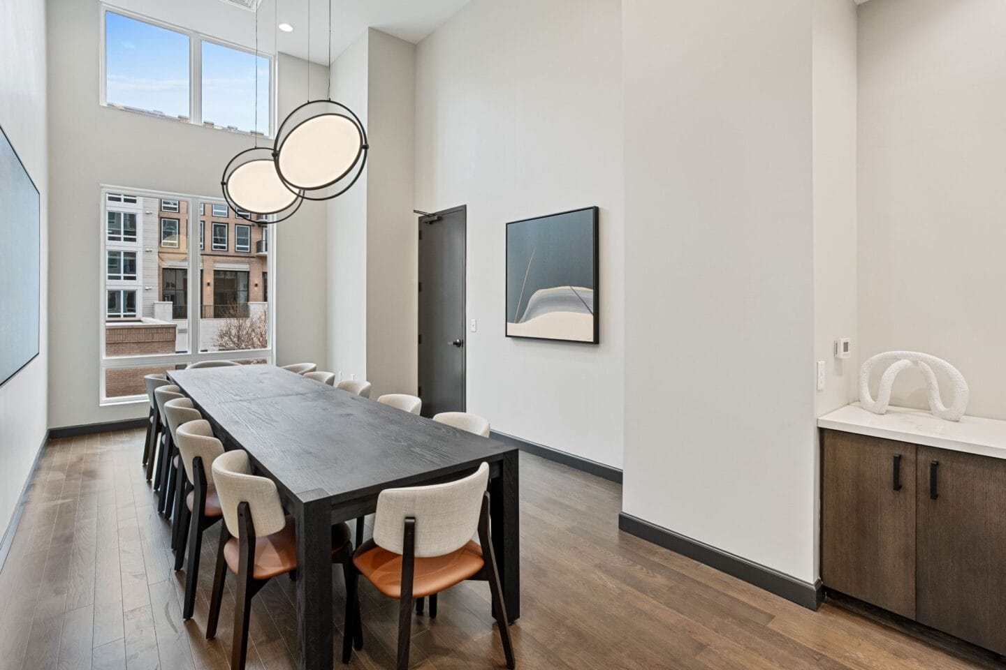 a dining room with a long table and chairs and a large window