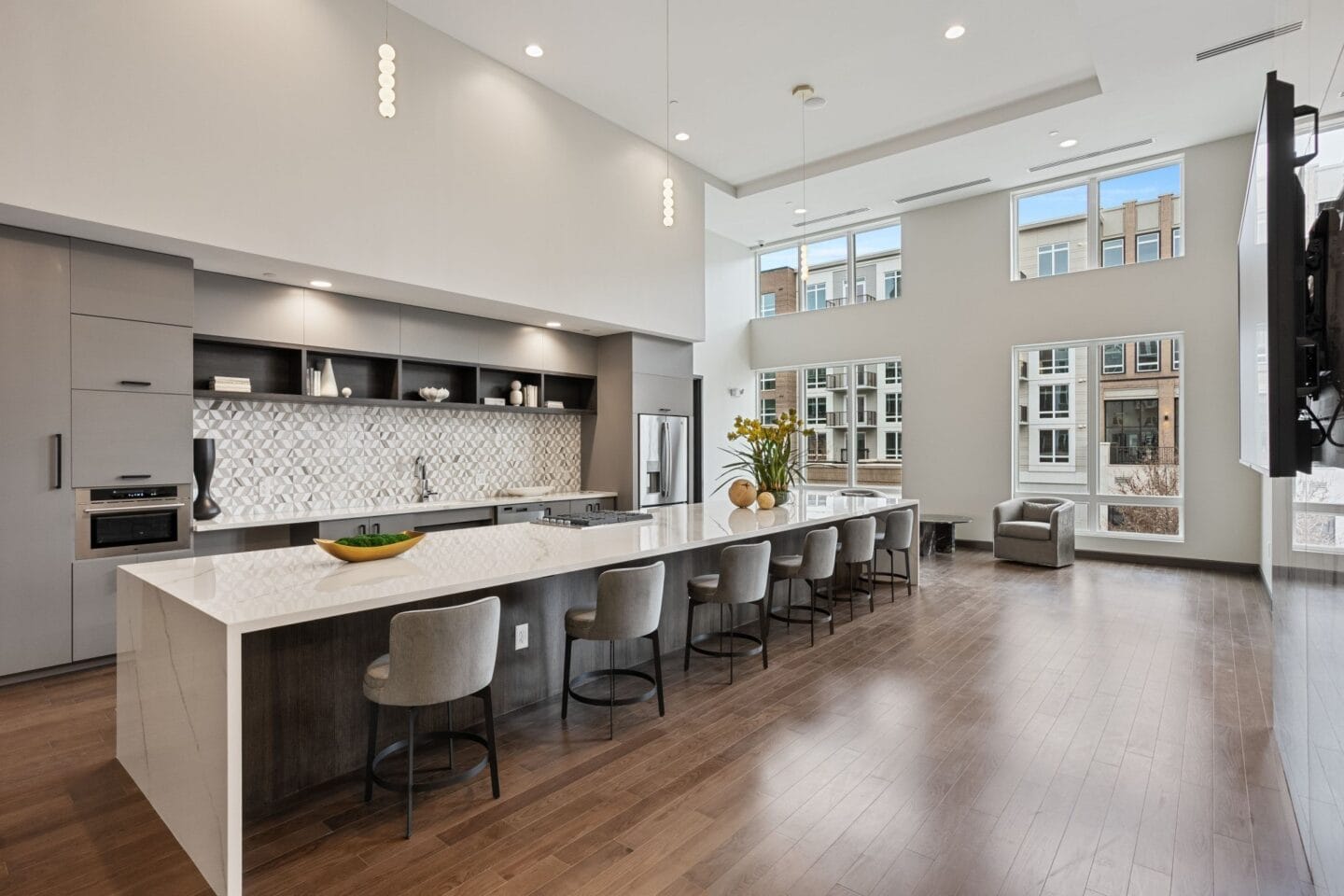 a large kitchen with a large island and chairs in a living room