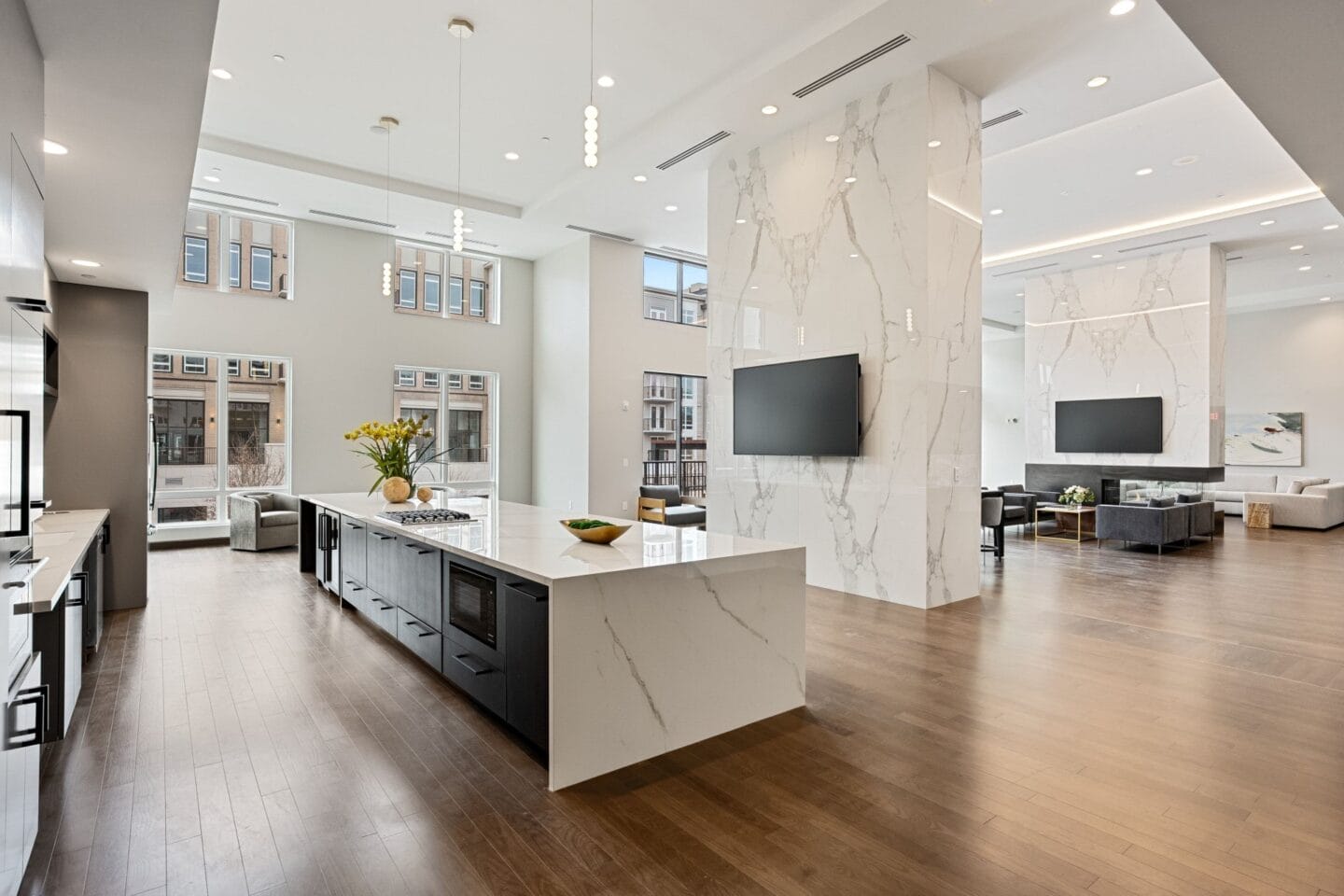 an open kitchen and living room with a marble pillar and a tv