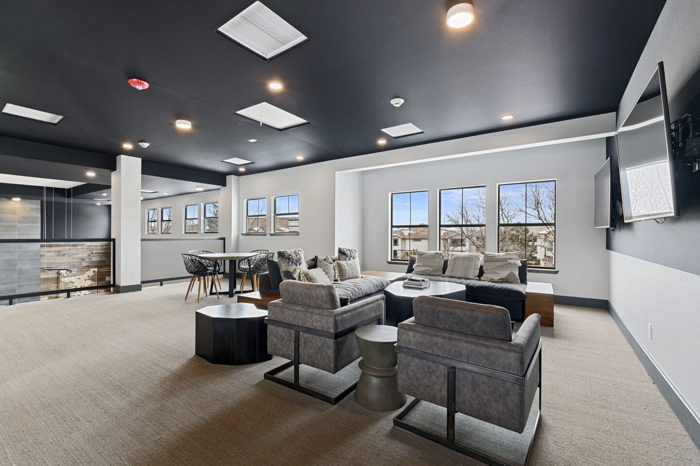 a community room with couches and chairs and a table and a tv  a c