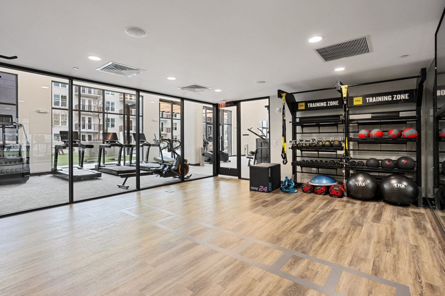 a gym with weights and other exercise equipment on a wooden floor