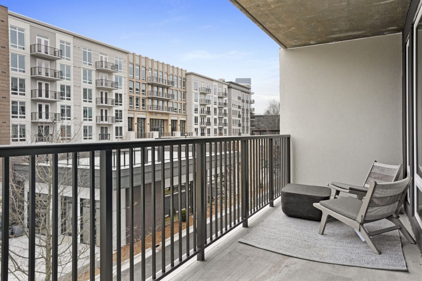 a balcony with a chair and two chairs on it and a view of a building