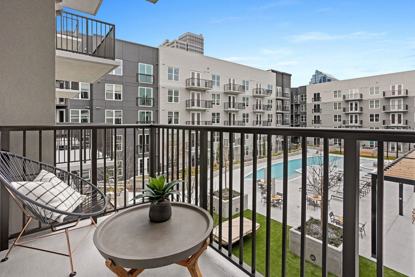 a balcony with a pool and a patio with chairs and a table