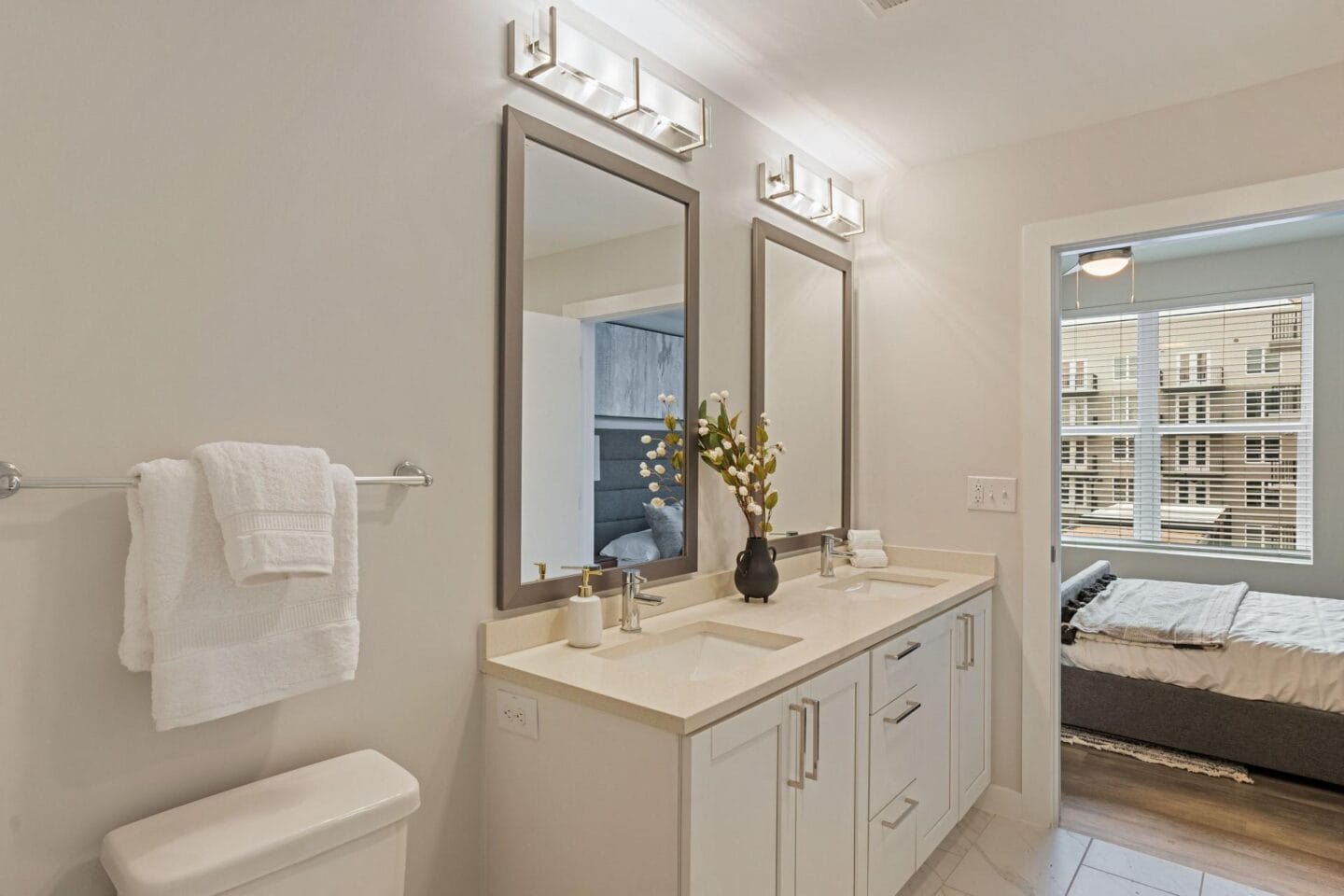 a white bathroom with two mirrors and a sink