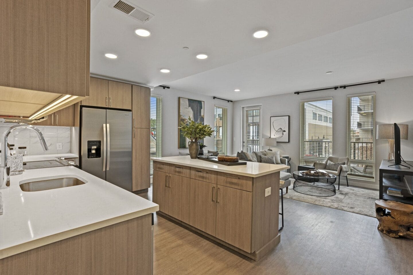 a kitchen and living room with a sink and a refrigerator