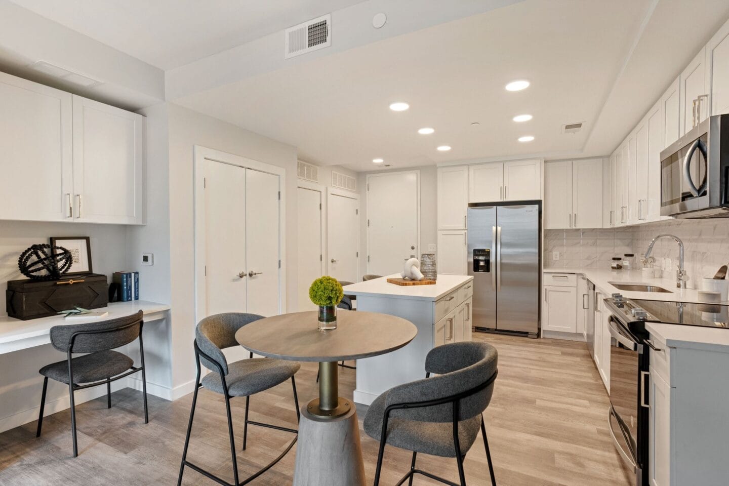 a kitchen with white cabinets and a table with four chairs