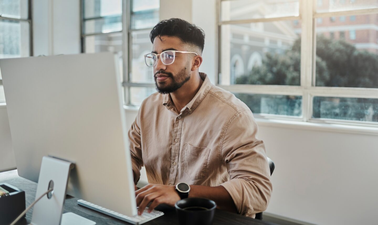 a person sitting at a desk using a computer