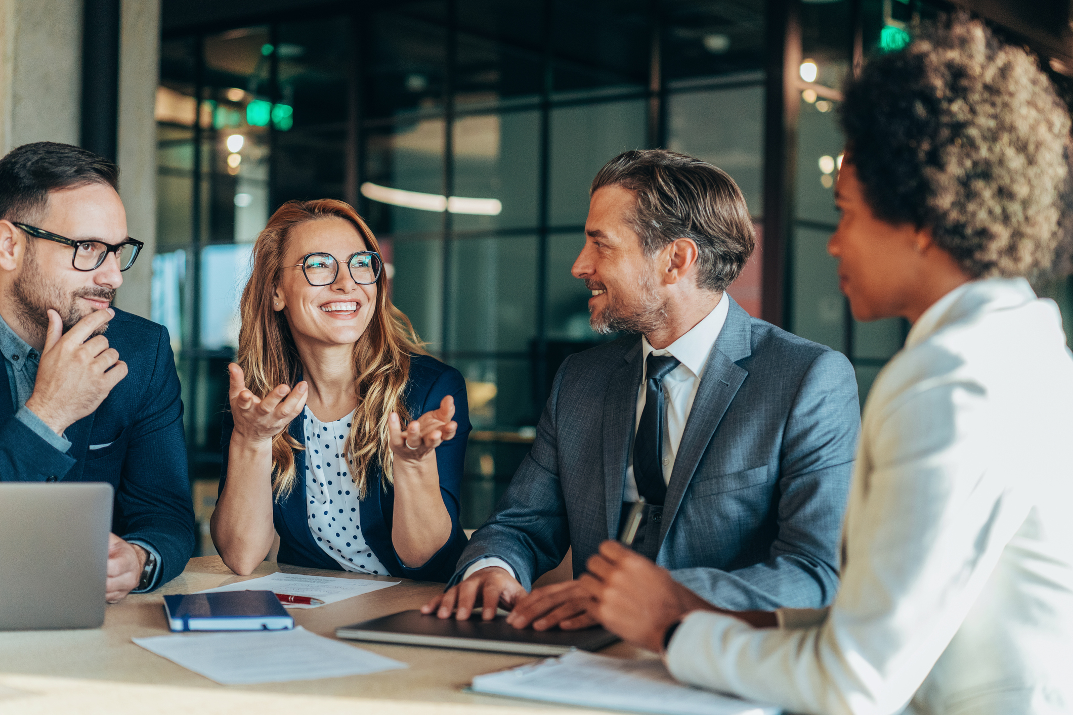 Business individuals collaborating in a meeting room, exchanging ideas and strategies in a professional office environment.